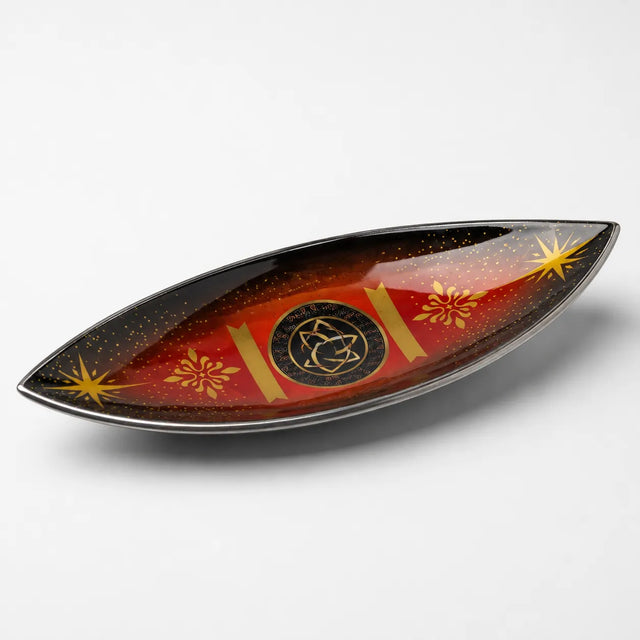 Dekoruotas laivelio formos smilkalinė su auksiniais ornamentais raudoname ir juodame fone.