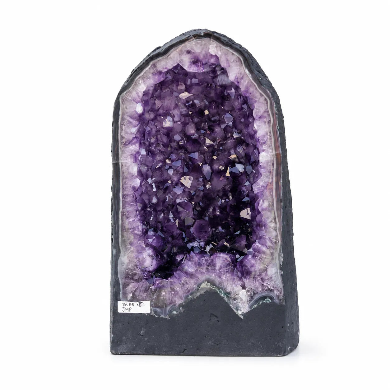 Didelė natūrali ametisto geoda su ryškiai violetiniais kristalais baltame fone.