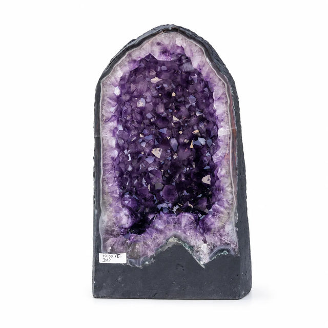 Didelė natūrali ametisto geoda su ryškiai violetiniais kristalais baltame fone.